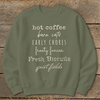 Olive sweatshirt with list of phrases: hot coffee, barn cats, early chores, frosty fences, fresh biscuits, quiet fields.