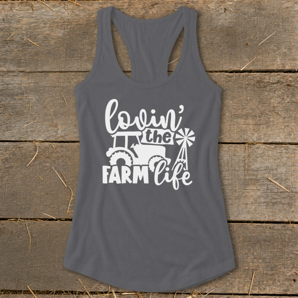 Gray tank top with white text and graphics reading "lovin' the farm life" with a tractor and windmill.