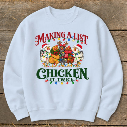 Light blue sweatshirt with cartoon chickens wearing Santa hats and Christmas lights, reads "Making a list, chicken it twice".