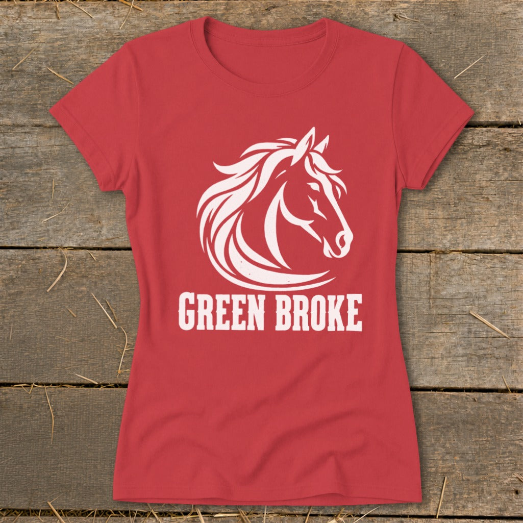A red short-sleeved t-shirt featuring a white horse graphic and the text GREEN BROKE on a wooden background.