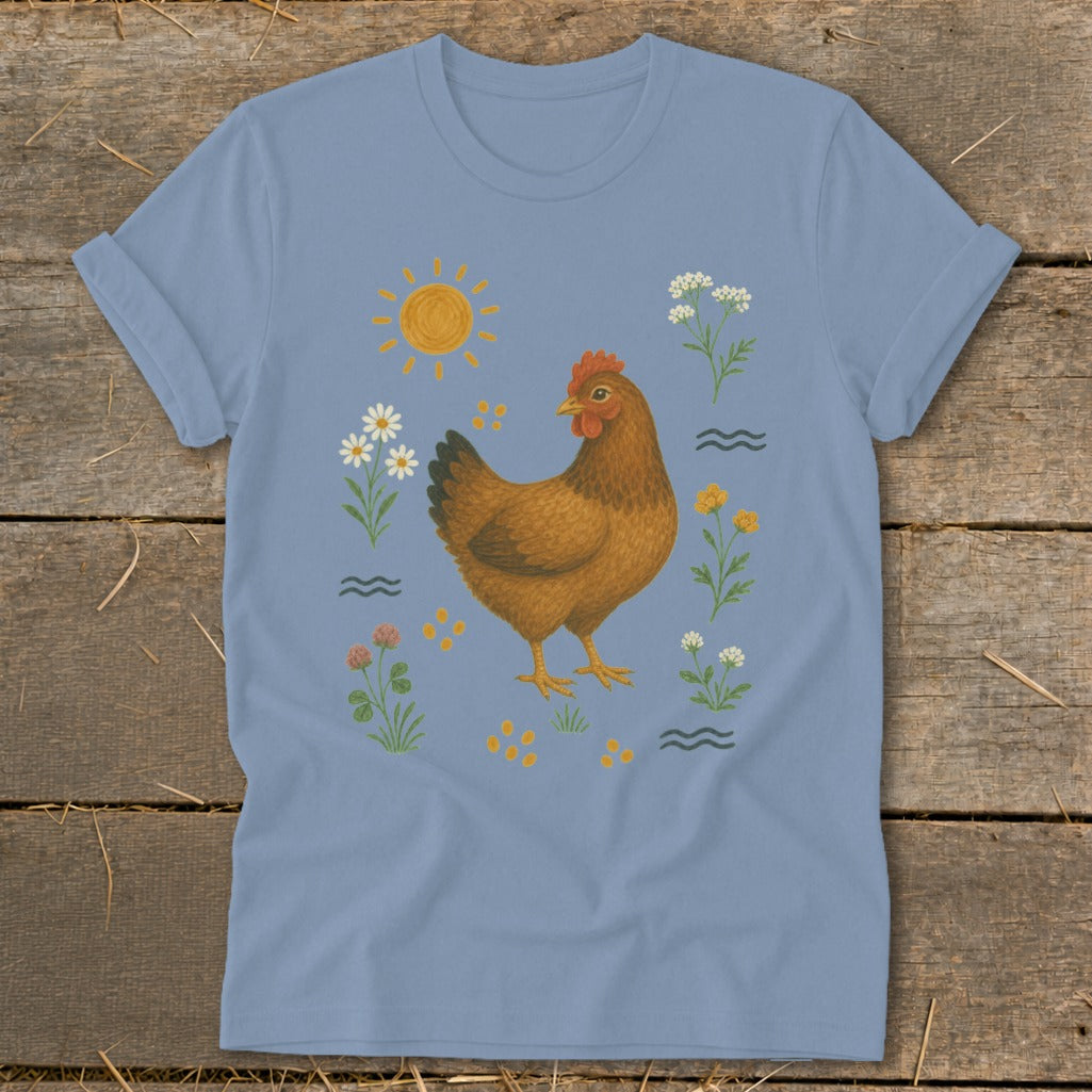 Light blue t-shirt with a brown hen illustration surrounded by wildflowers and a sun.