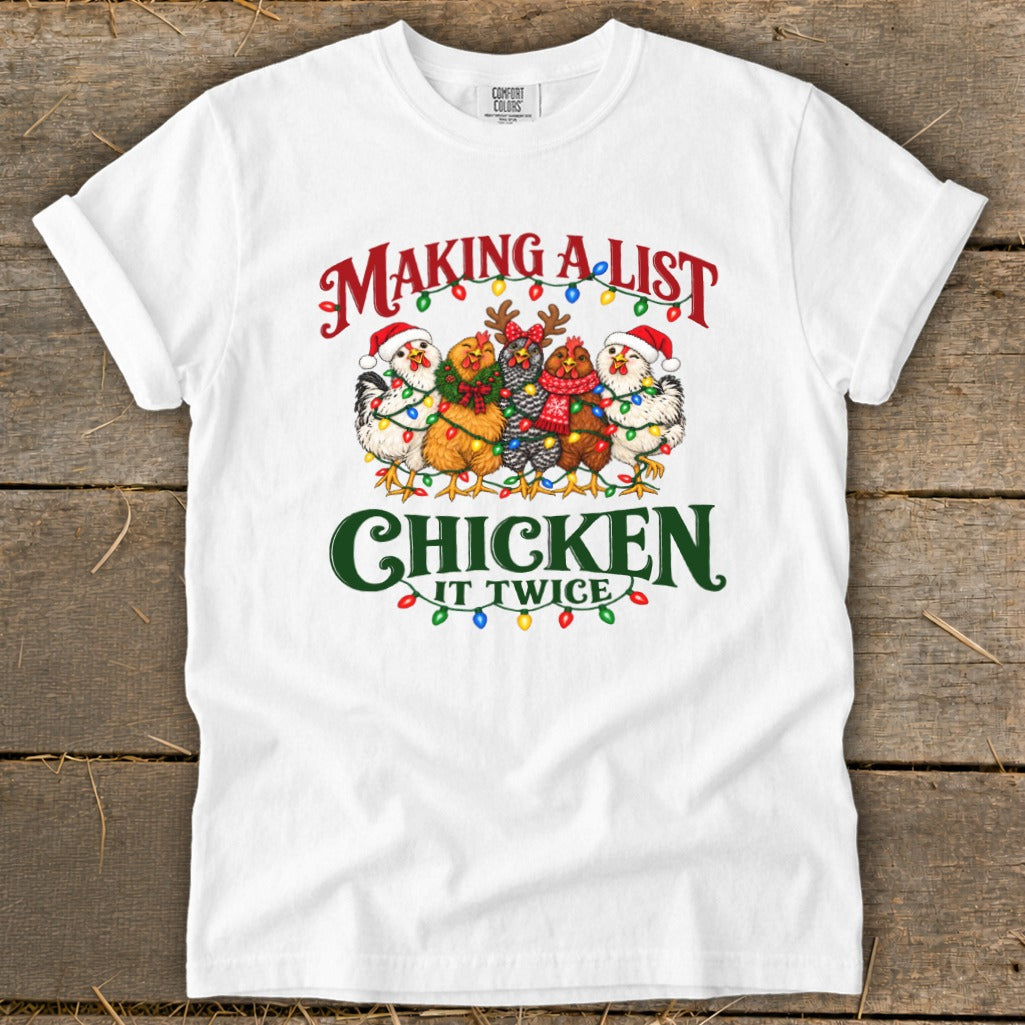 White t-shirt with "Making a list chicken it twice" text and festive chickens.