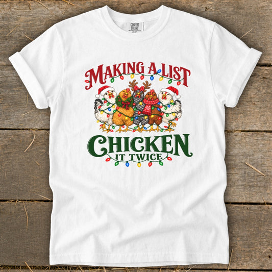 White t-shirt with "Making a list chicken it twice" text and festive chickens.