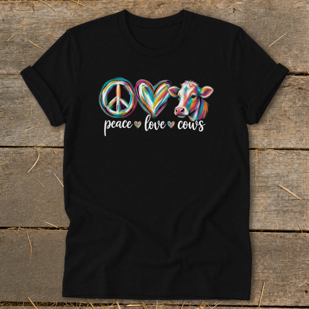 A black t-shirt featuring the text "peace love cows" with colorful artistic symbols and a cow illustration.
