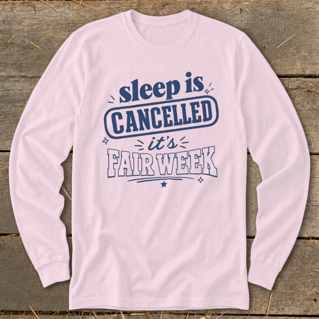 Pink long sleeve shirt with "sleep is CANCELLED it's FAIR WEEK" graphic.