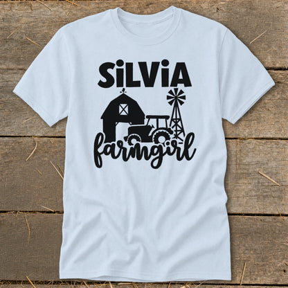 Light blue t-shirt with "Silvia farmgirl" text and barn, tractor, and windmill graphic.