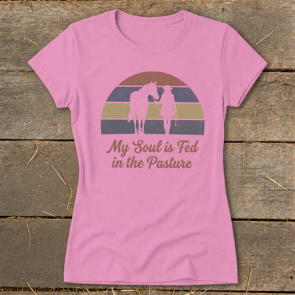 Pink t-shirt with horse and rider silhouette and "My Soul is Fed in the Pasture" text.
