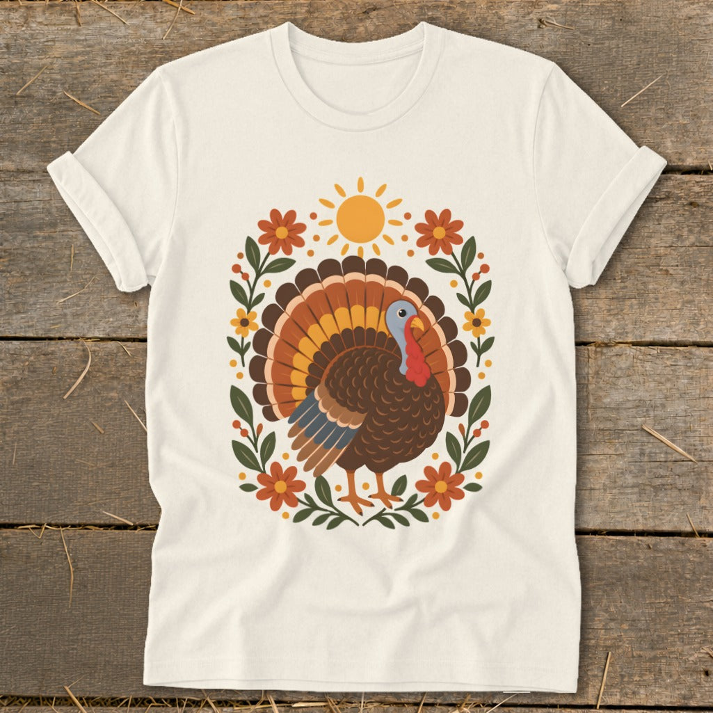 Cream t-shirt with a colorful turkey illustration surrounded by flowers and a sun.