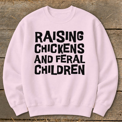 Pink sweatshirt with black text "RAISING CHICKENS AND FERAL CHILDREN".