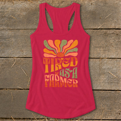 Pink racerback tank top with "Tired as a Farmer" text and colorful sun graphic.