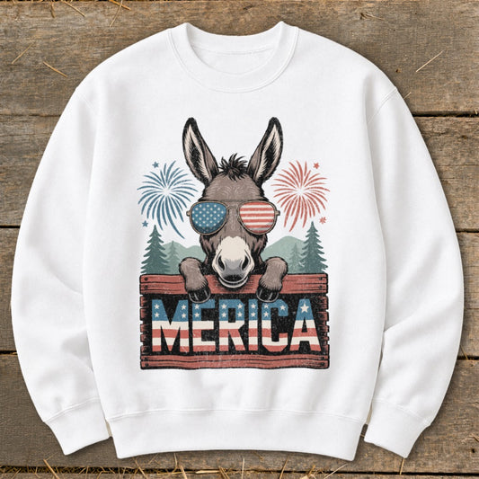 Donkey wearing American flag sunglasses and holding "MERICA" sign with fireworks.