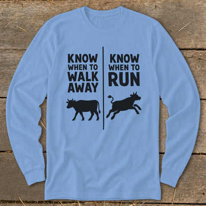 Light blue long-sleeve shirt with black text and cow silhouettes.