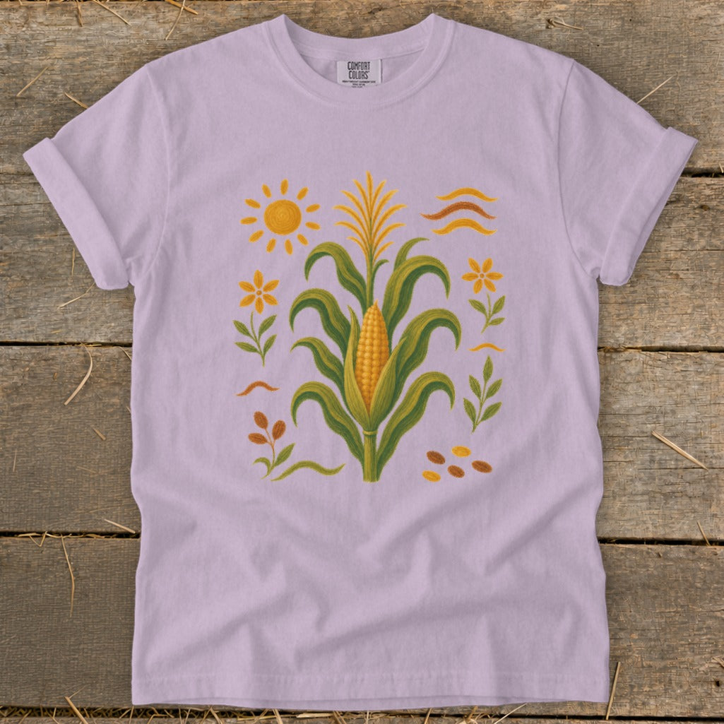 Purple t-shirt with embroidered corn stalk, sun, flowers, leaves, and kernels.