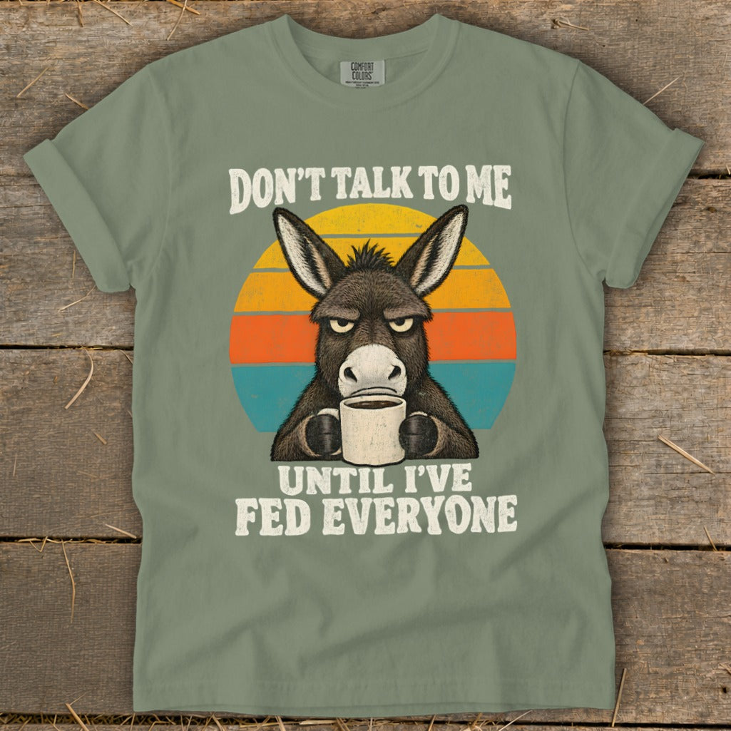 Sage green t-shirt with a grumpy donkey drinking coffee and text reading Don't Talk to Me Until I've Fed Everyone.