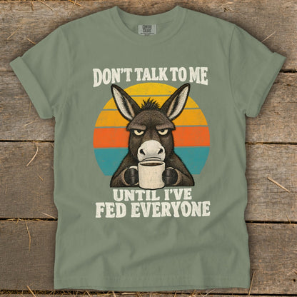 Sage green t-shirt with a grumpy donkey drinking coffee and text reading Don't Talk to Me Until I've Fed Everyone.