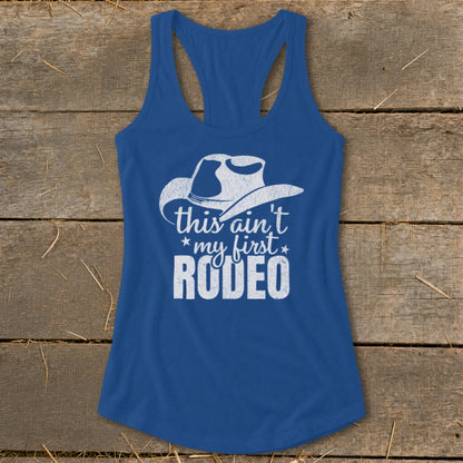 Blue tank top with white cowboy hat graphic and "this ain't my first RODEO" text.