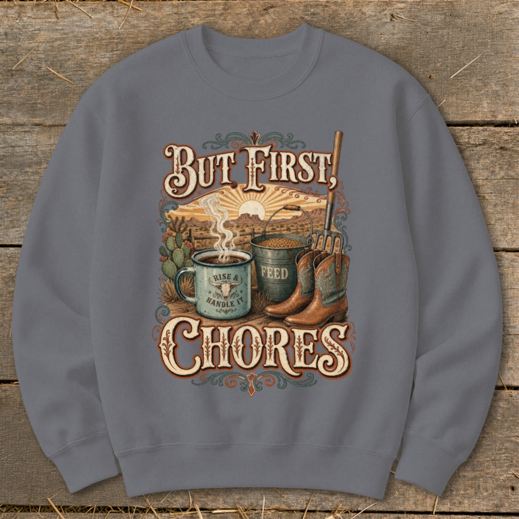 Crewneck sweatshirt with desert scene, coffee, feed bucket, boots, and text "But First, Chores".