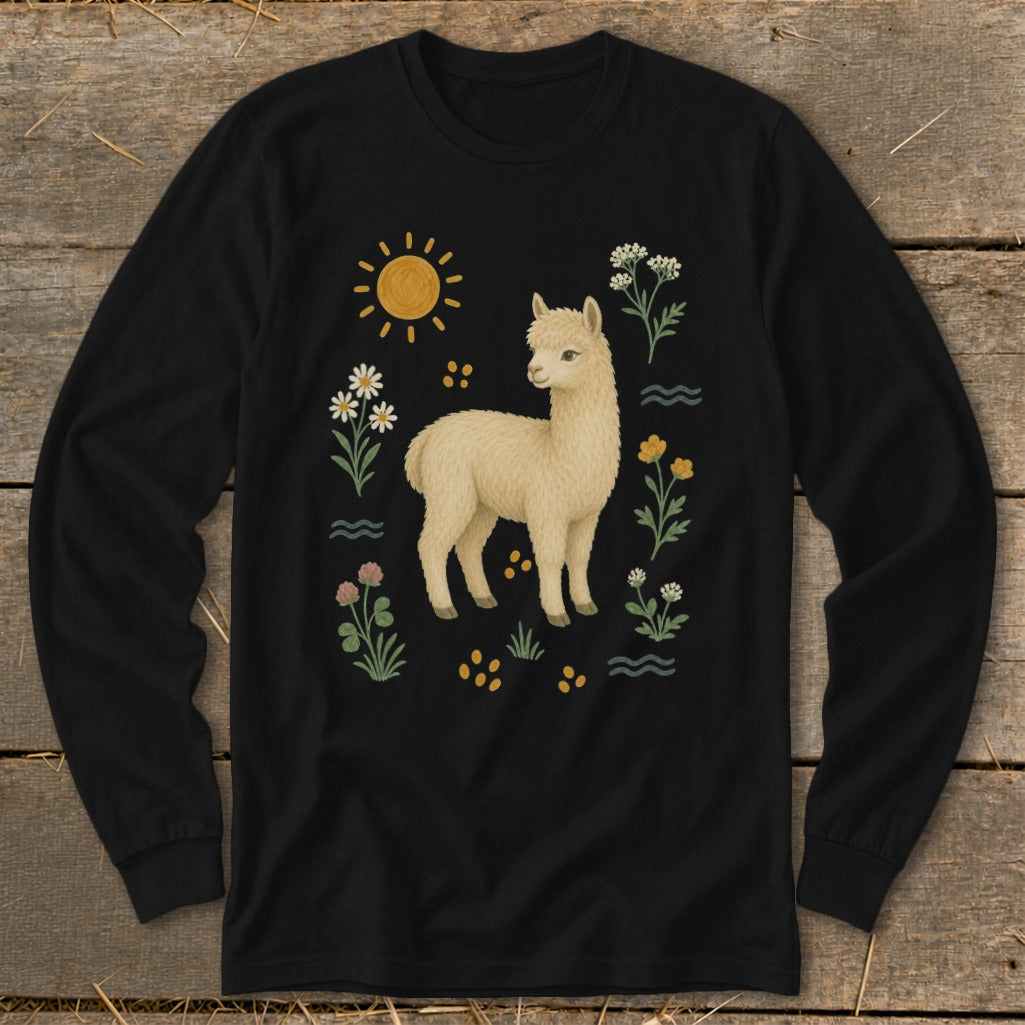 A black long-sleeved shirt featuring a painted illustration of a cream-colored alpaca surrounded by flowers, grass, and a sun.