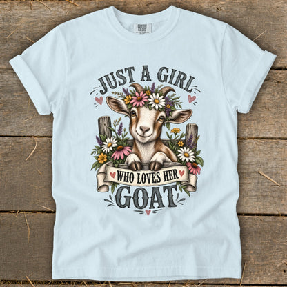 Light blue t-shirt with "Just a girl who loves her goat" graphic featuring a smiling goat.