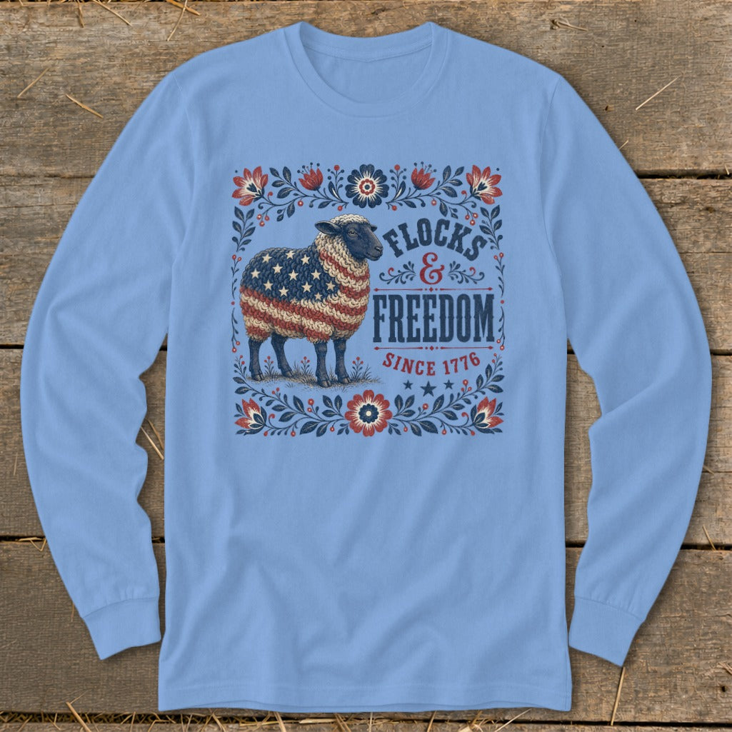 Sheep with American flag pattern on fleece shirt with "Flocks & Freedom Since 1776" text.