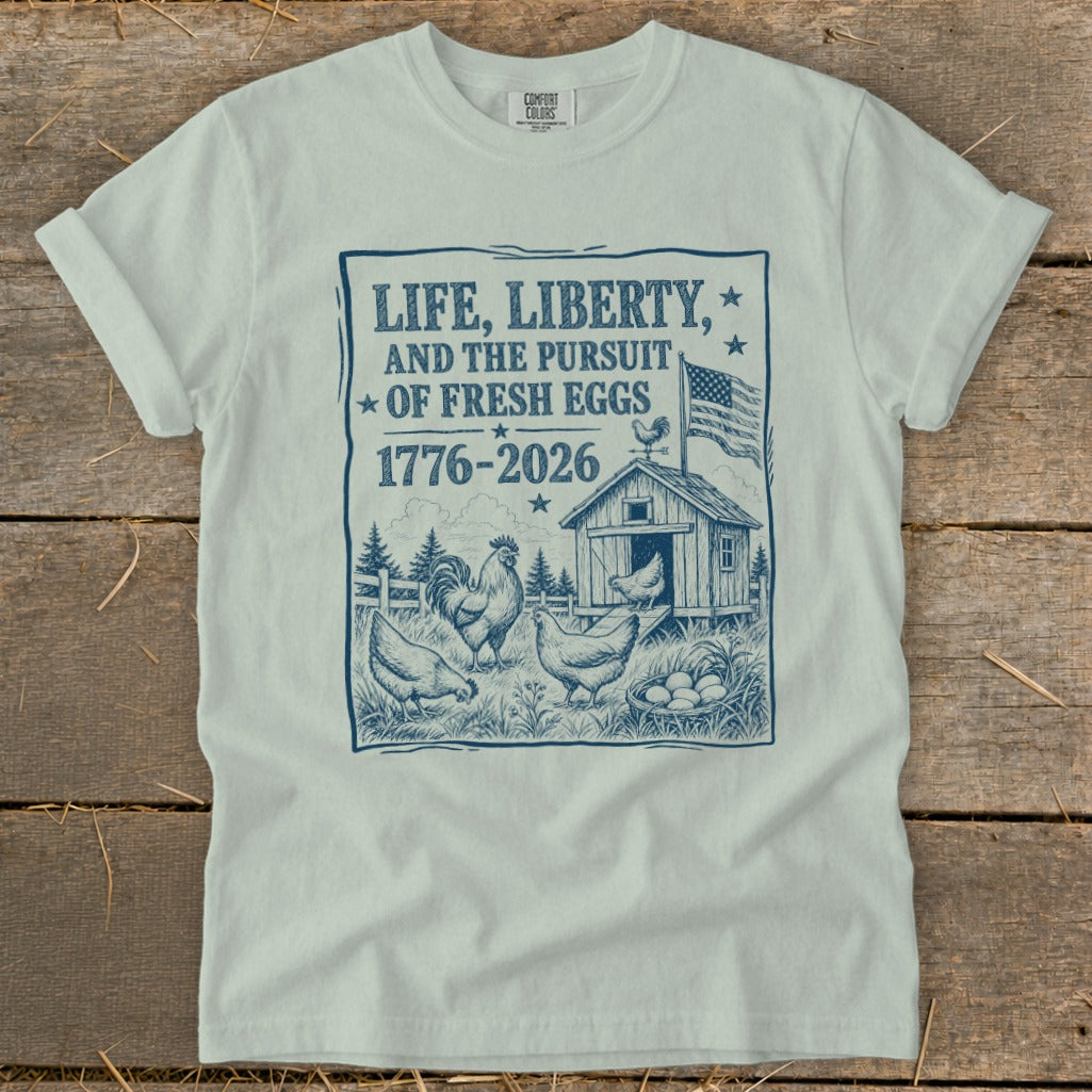 Life, liberty, and the pursuit of fresh eggs 1776-2026 graphic with chickens and barn.
