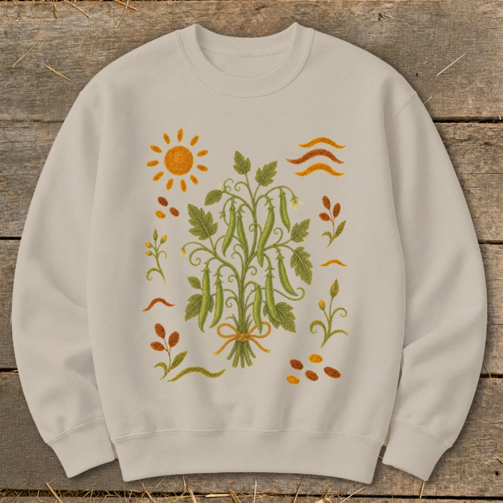 Light beige sweatshirt with a central embroidered pea plant surrounded by sun, leaves, and seeds.