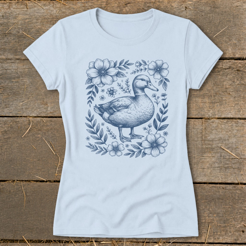Light blue t-shirt with a blue line drawing of a mallard duck surrounded by flowers.