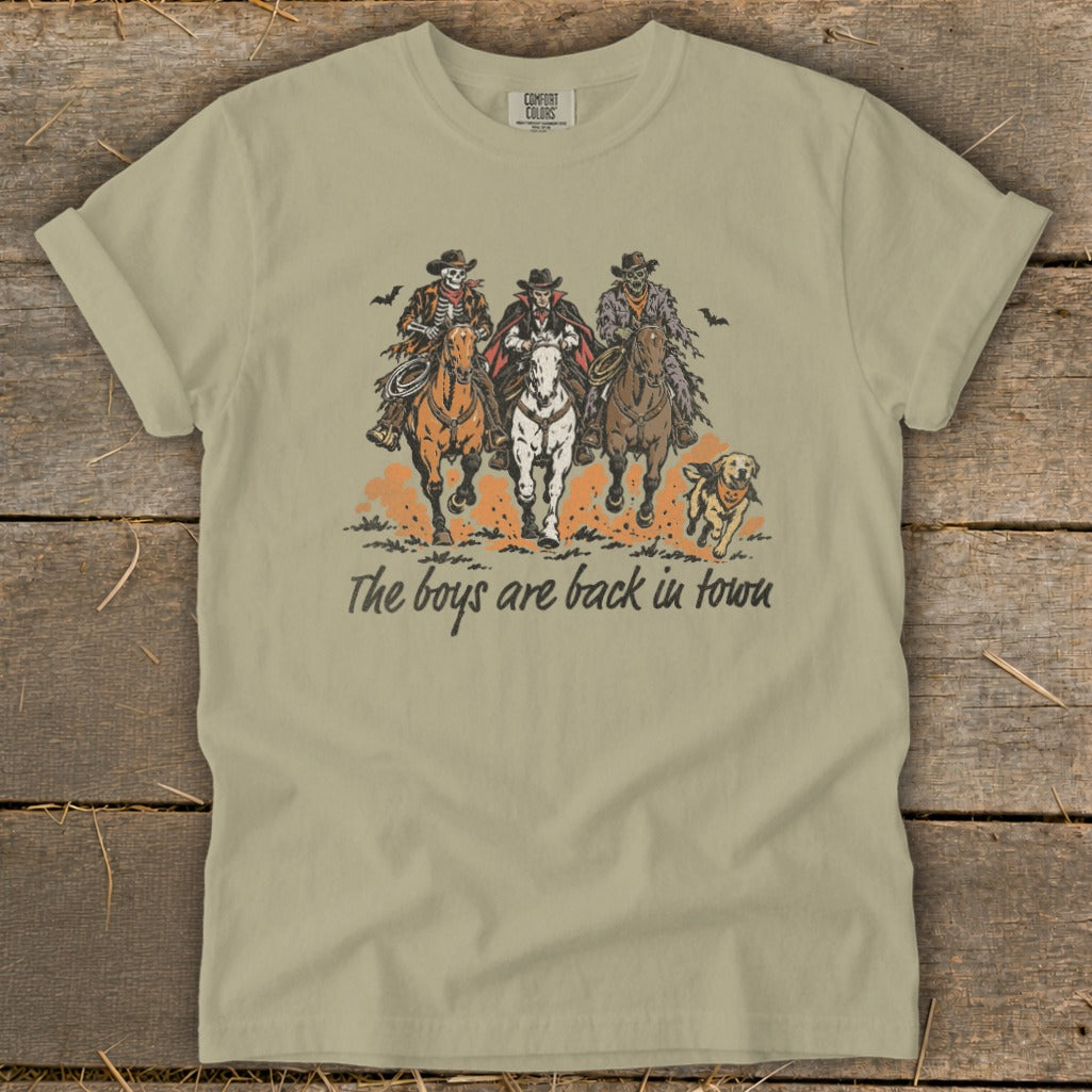 Skeleton, vampire, zombie cowboys ride horses with dog, text: The boys are back in town.