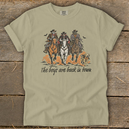 Skeleton, vampire, zombie cowboys ride horses with dog, text: The boys are back in town.