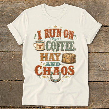 White t-shirt with distressed text "I run on coffee, hay and chaos" and graphics.