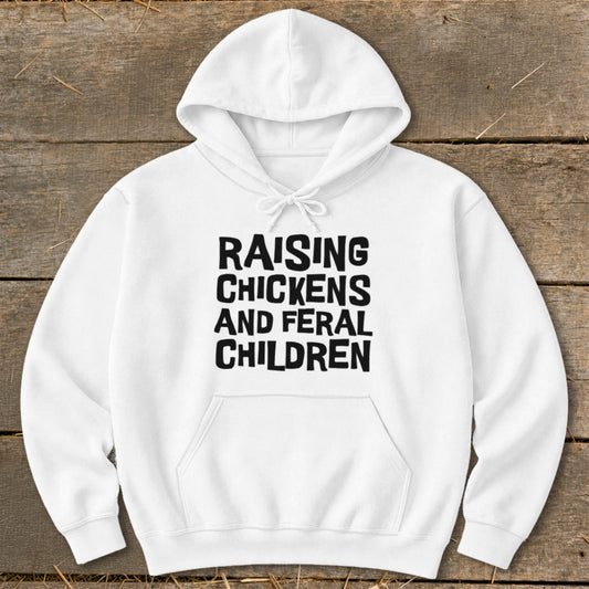 White hoodie with black text reading "RAISING CHICKENS AND FERAL CHILDREN".