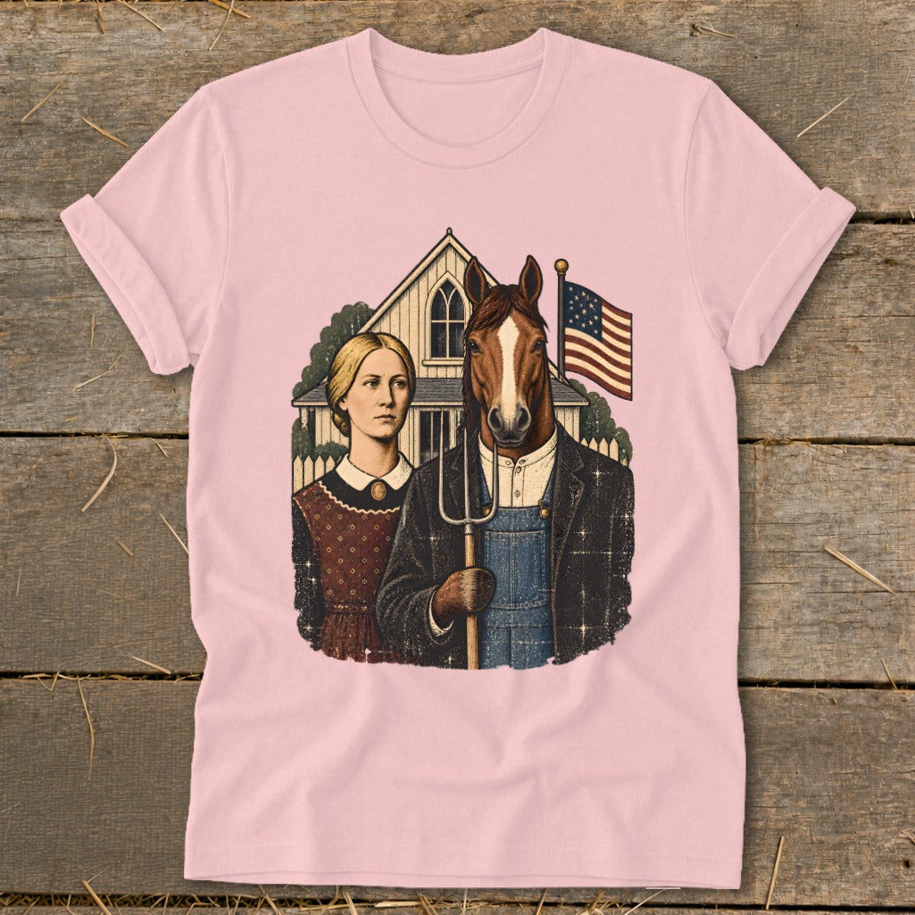 Light pink t-shirt featuring a satirical American Gothic parody graphic with a woman and a horse-headed farmer holding a pitchfork.