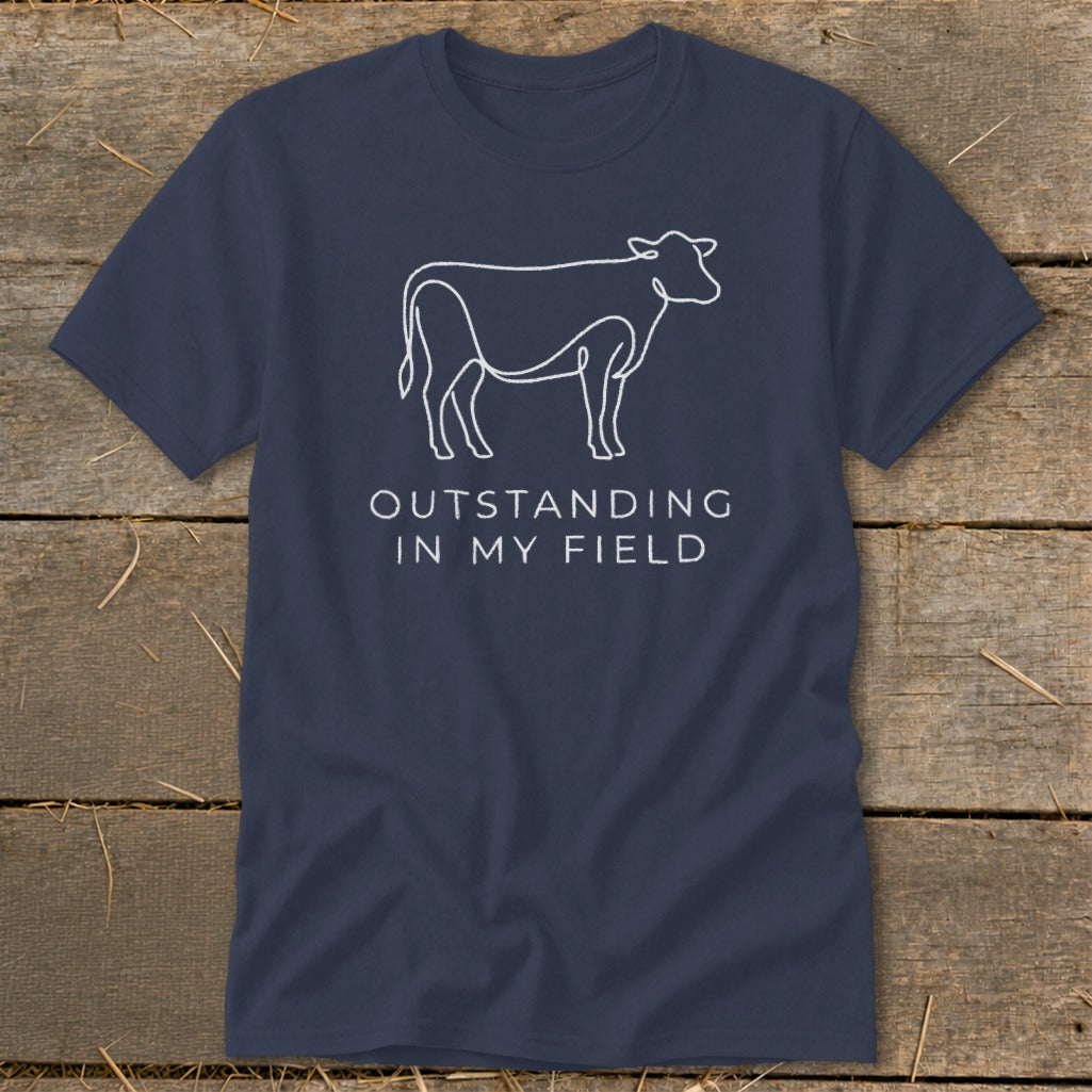 Navy t-shirt with white line drawing of a cow and text "OUTSTANDING IN MY FIELD".