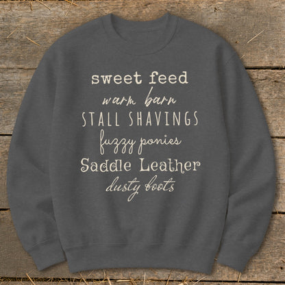 Gray sweatshirt with text: sweet feed, warm barn, STALL SHAVINGS, fuzzy ponies, Saddle Leather, dusty boots.