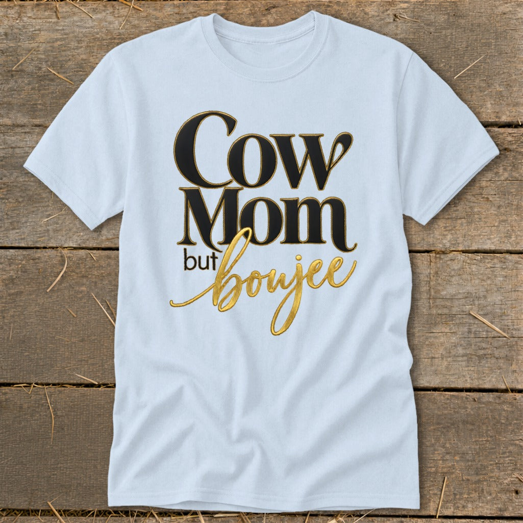 White t-shirt with "Cow Mom but boujee" text in gold and black.