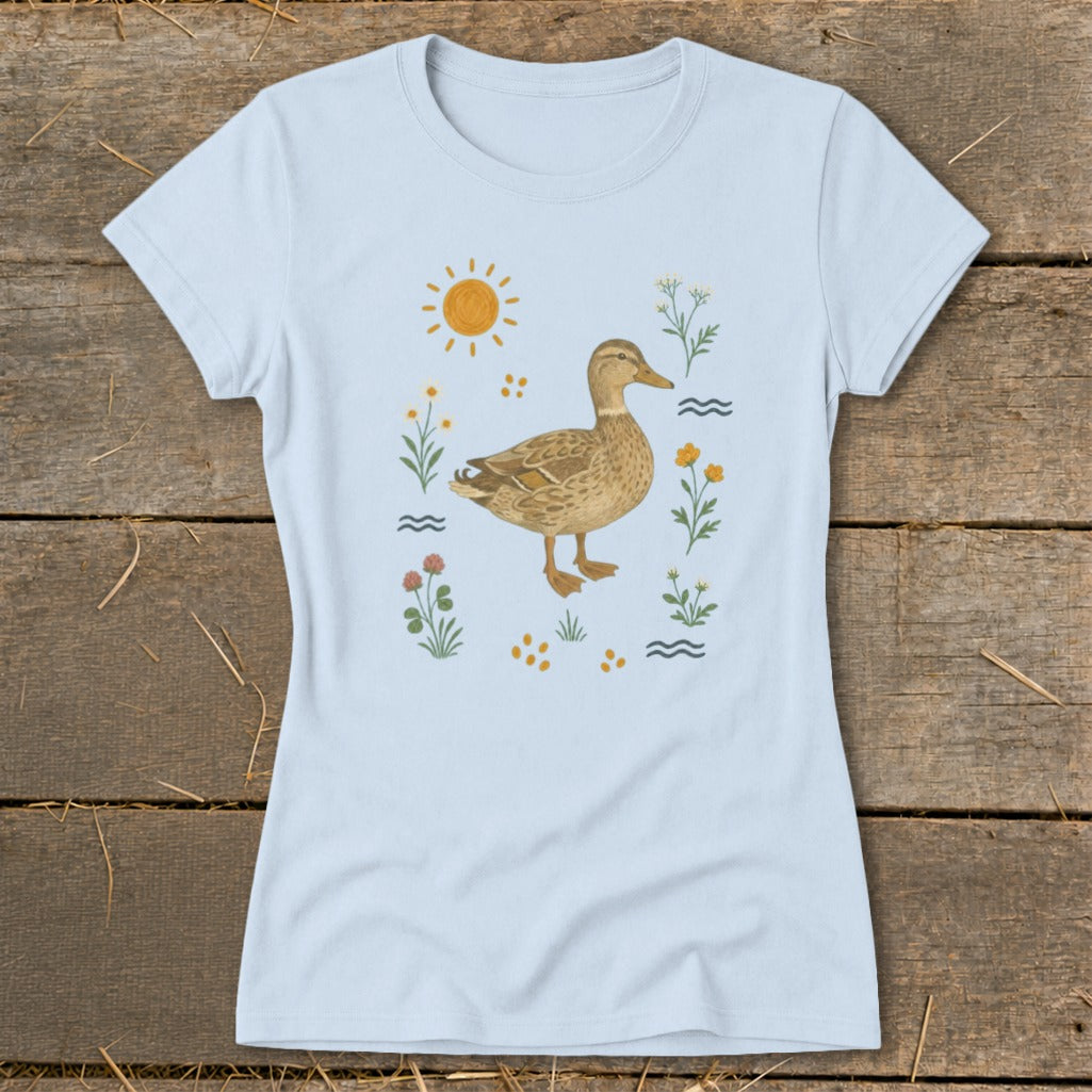 Light blue t-shirt with a mallard duck illustration surrounded by flowers and sun.
