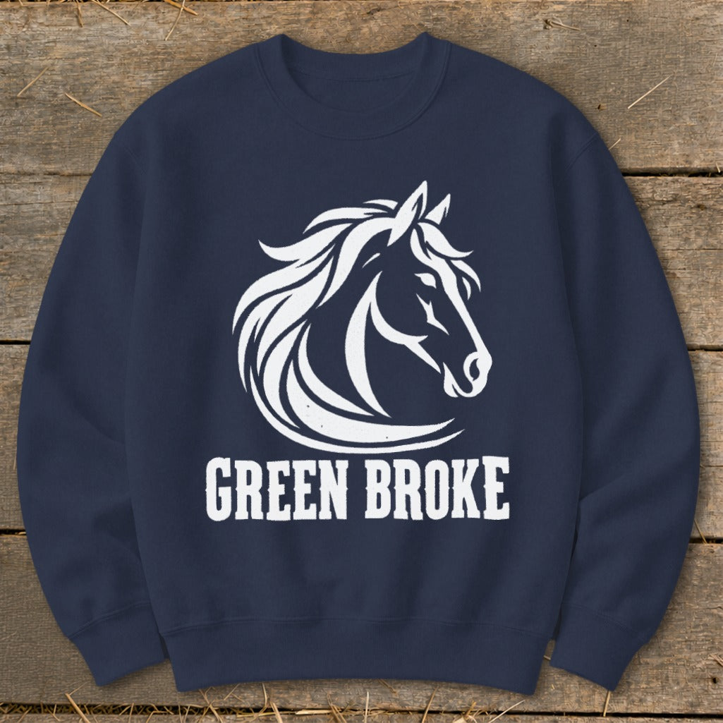 A navy blue crewneck sweatshirt featuring a white graphic of a horse head and the text GREEN BROKE on a wooden background.