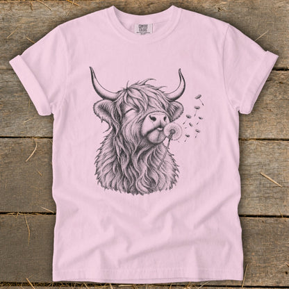 Pink t-shirt featuring a black sketch of a highland cow blowing dandelion seeds.