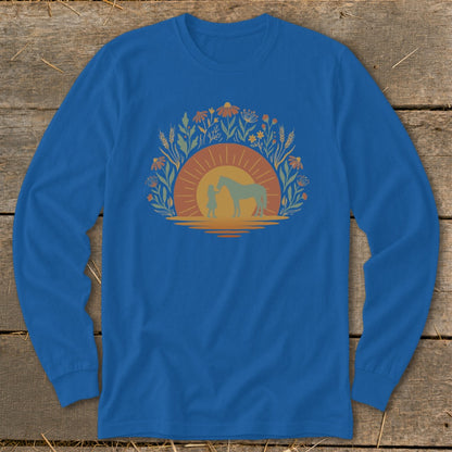 Blue long sleeve shirt with a graphic of a person and horse at sunset within a floral arch.