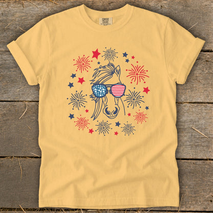 Yellow t-shirt with horse wearing American flag sunglasses, surrounded by fireworks and stars.