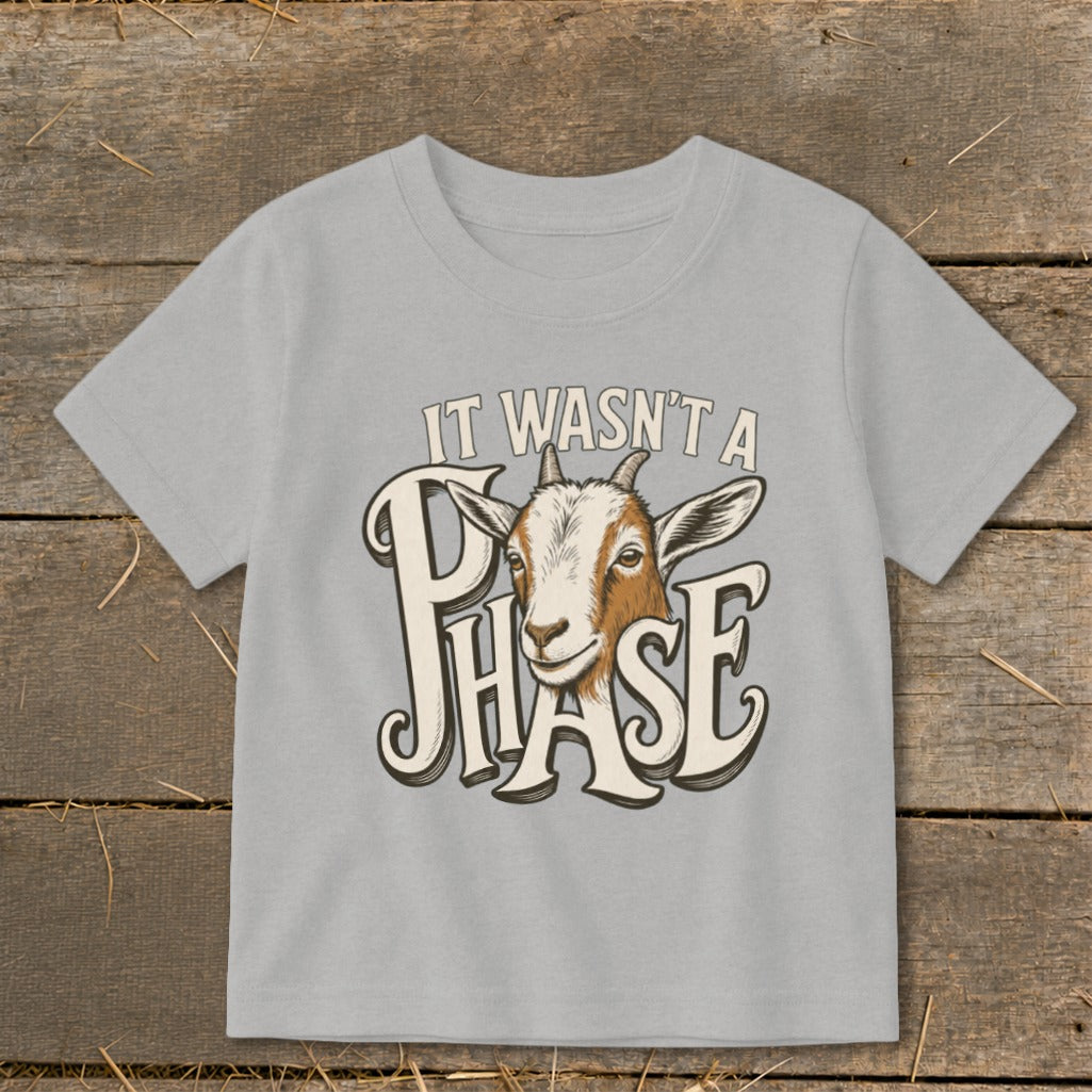 Light gray t-shirt with a goat head graphic and text "IT WASN'T A PHASE".