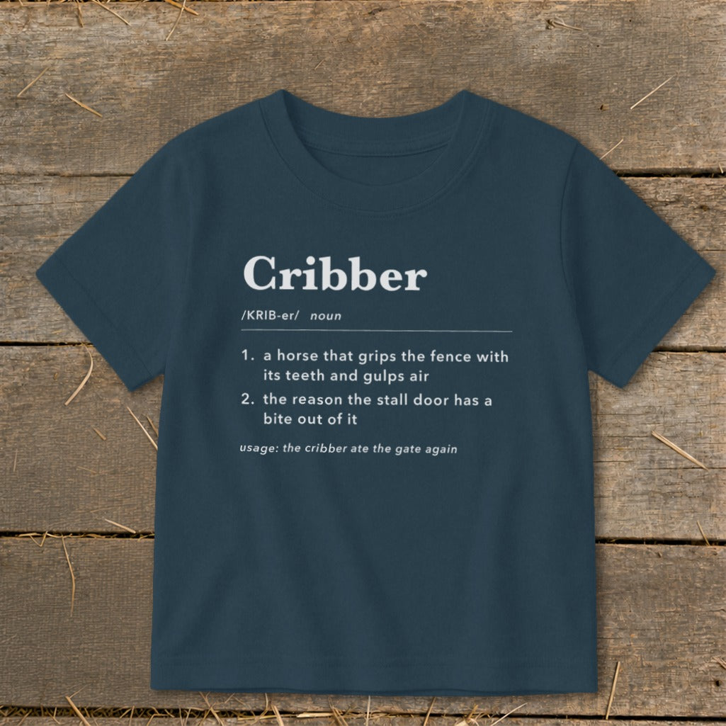 A dark blue t-shirt printed with a dictionary definition of the word Cribber in white text.