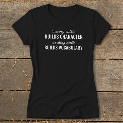 Black t-shirt with white text: "raising cattle BUILDS CHARACTER working cattle BUILDS VOCABULARY".