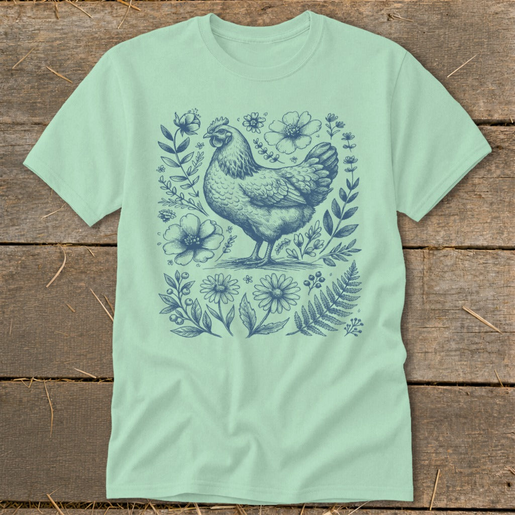 Mint t-shirt with a blue line drawing of a chicken surrounded by flowers and leaves.