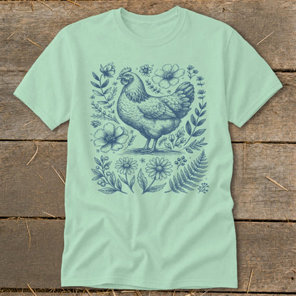 Mint t-shirt with a blue line drawing of a chicken surrounded by flowers and leaves.