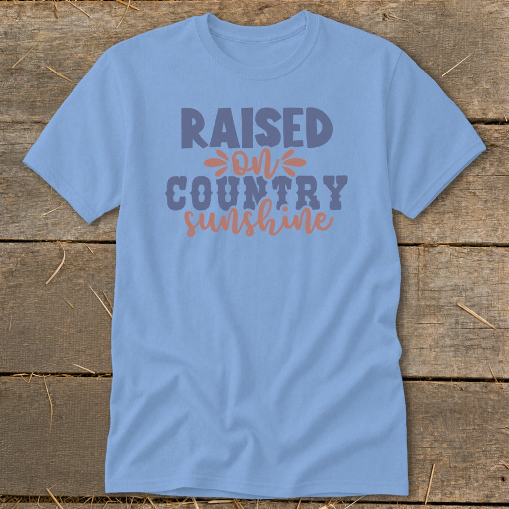 Light blue t-shirt with "Raised on Country Sunshine" text in purple and orange.
