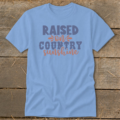 Light blue t-shirt with "Raised on Country Sunshine" text in purple and orange.