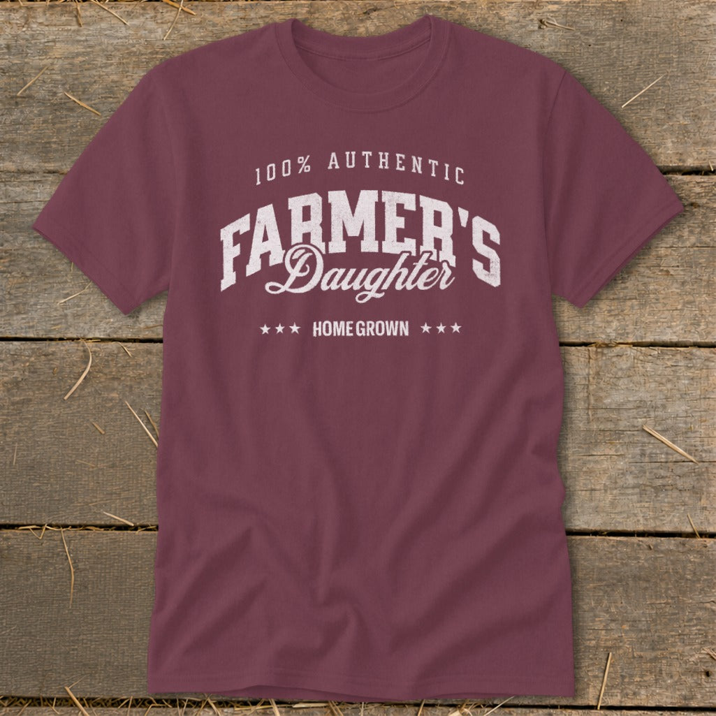 Maroon t-shirt with white text reading "100% AUTHENTIC FARMER'S DAUGHTER HOME GROWN".