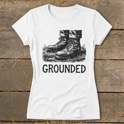 White t-shirt with a graphic of boots in grass and the word "GROUNDED".