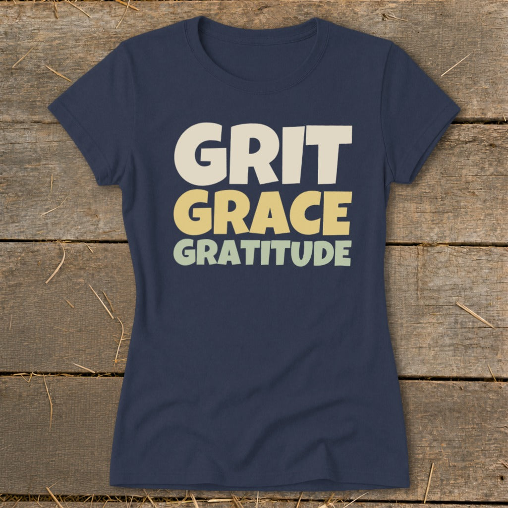 Dark blue women's t-shirt printed with the words Grit, Grace, and Gratitude in stacked, blocky lettering.